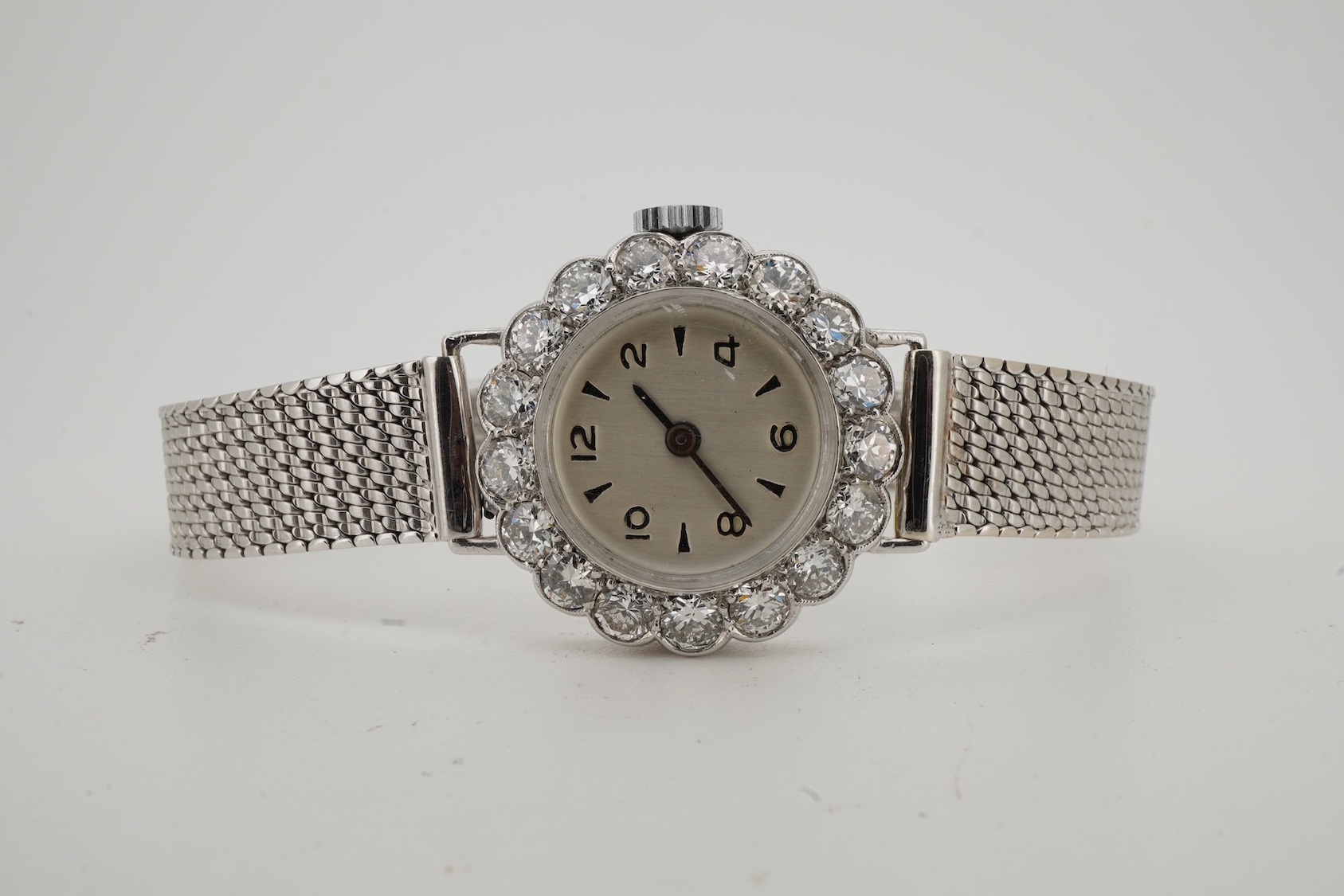 A lady's early 1940's platinum and diamond set manual wind cocktail watch, on a 9ct white gold mesh link bracelet